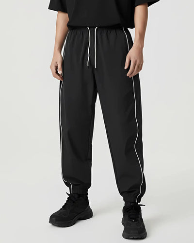 Reflective Nightflow Hose in Schwarz, lässig getragen, ideal für Techno und Rave.