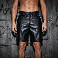 Schwarze Nightshift Shorts vor Betonwand, Vorderansicht am Model