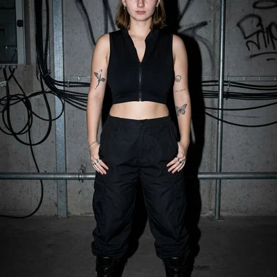 Model im schwarzen Rave Zip Top, gerade Pose, Club und Festival Style
