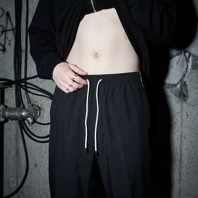 Nahaufnahme der Reflective Nightflow Hose, schwarzer Stoff, perfekt für Festivals.