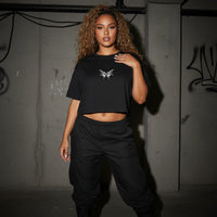 Schwarzes Tribal Techno Vibes Crop Top zu schwarzer Cargohose, Ganzkörper am Model #farbe_schwarz