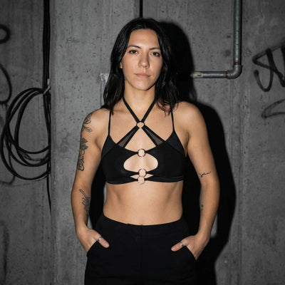 Model trägt X-Strap Mesh Bralette vor Betonwand, Techno Club Look